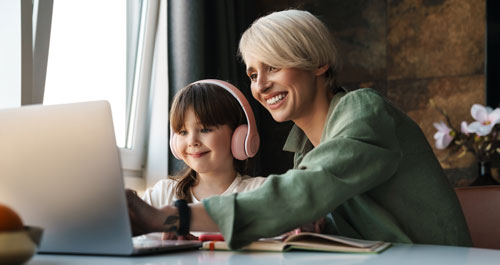 A mother and her daughter looking at the computer