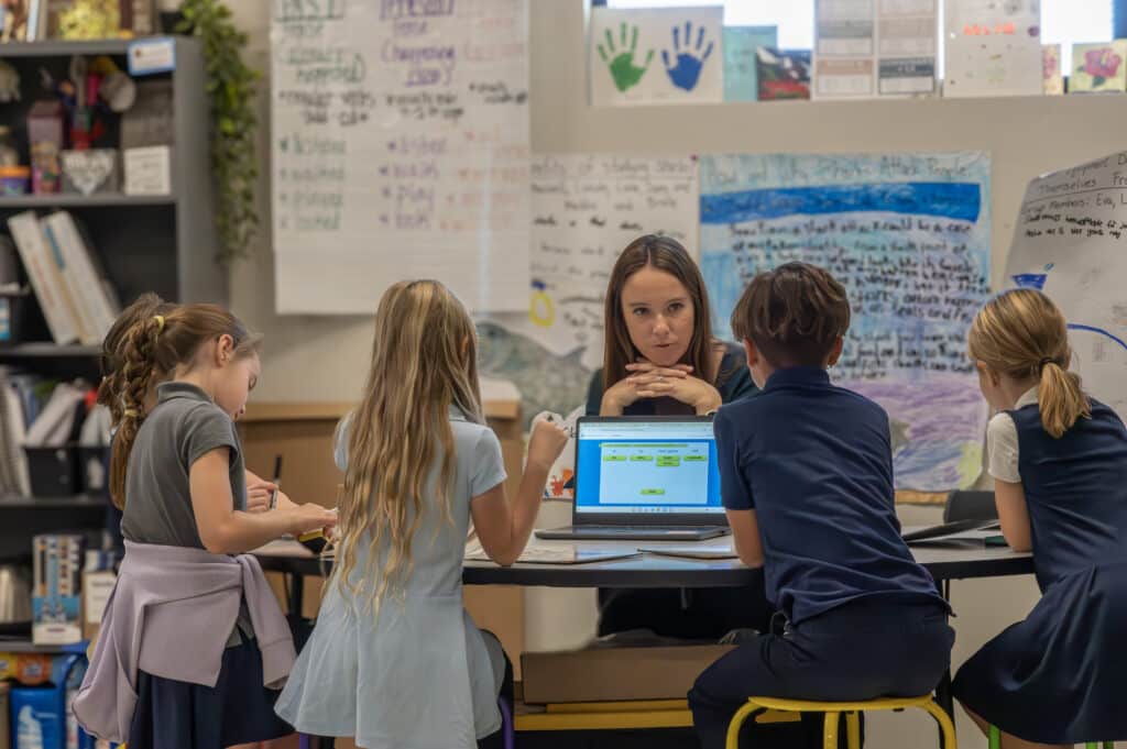Teacher guiding small group discussion in a classical classroom at Leman Academy