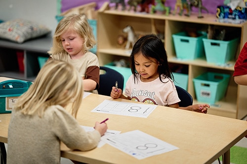 Teacher working with students in small preschool sizes