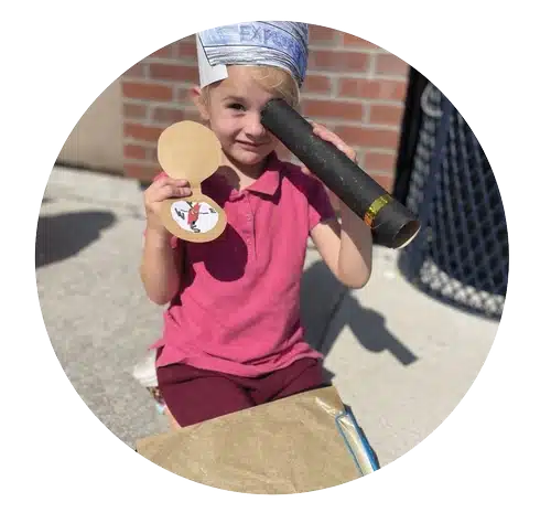 kindergartener looking through a black tube at Stroh Parker