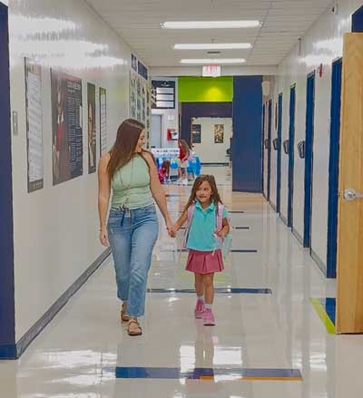 Mother and daughter walking down the hall