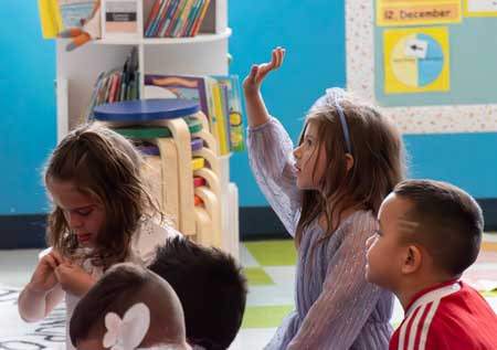 Leman Academy scholar rising hand in classroom at Parker Stroh campus