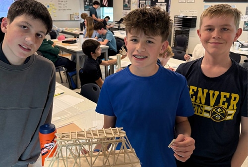 Image of scholars holding up a project they did in an elective class