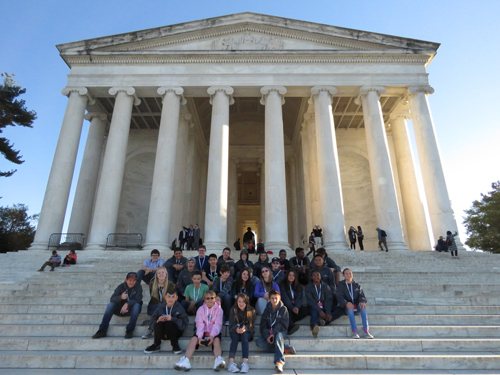 Washington D.C. trip photo of all of the scholars sitting on the steps.
